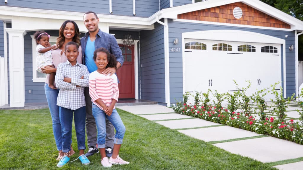 Happy family standing outside of their new house